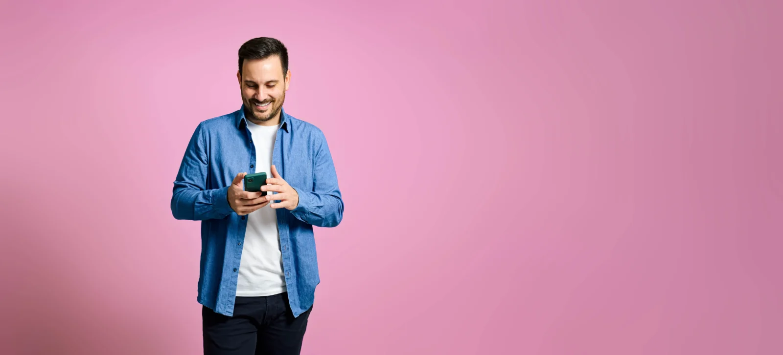 Homme tenant un iPhone et regardant vers son mobile