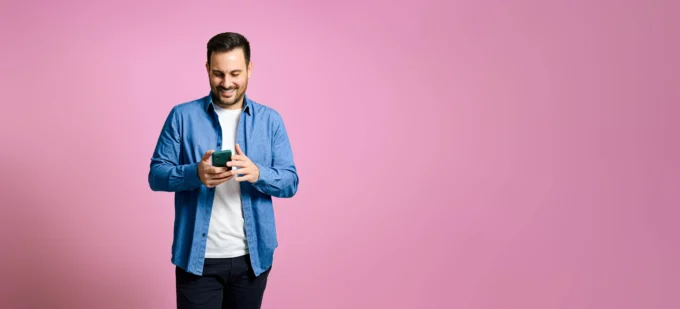 Homme tenant un iPhone et regardant vers son mobile