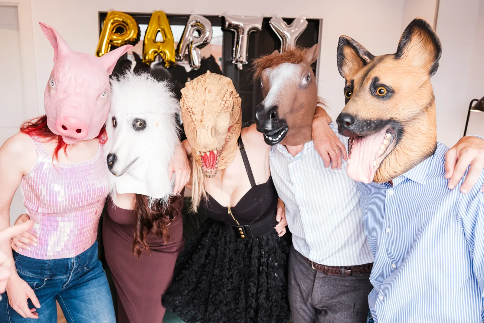 Personnes faisant des photos avec des masques dans un photo booth