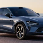 Xiaomi YU7, SUV électrique futuriste, design aérodynamique et jantes sport, stationné face à la mer au coucher du soleil.