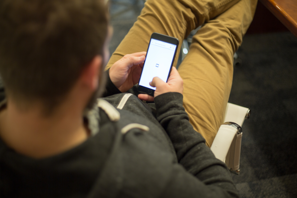 Personne effectuant une recherche sur son smartphone, écran de moteur de recherche affiché