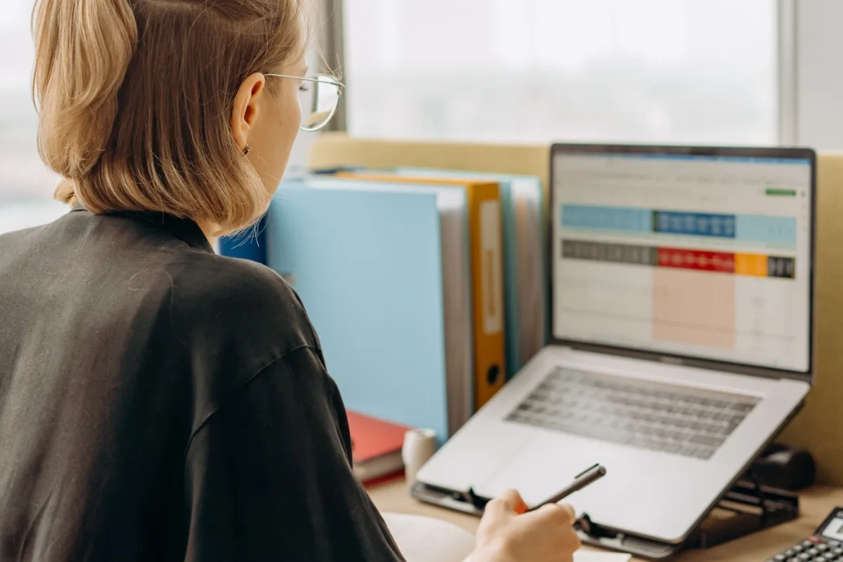 Une analyste marketing étudie un tableau de données de campagnes sur son ordinateur portable