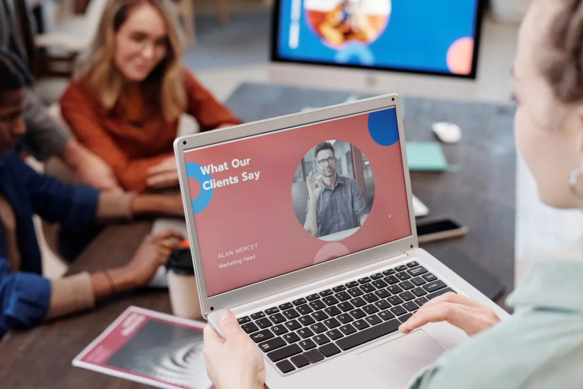 Une équipe marketing examine une présentation de références clients sur un ordinateur portable